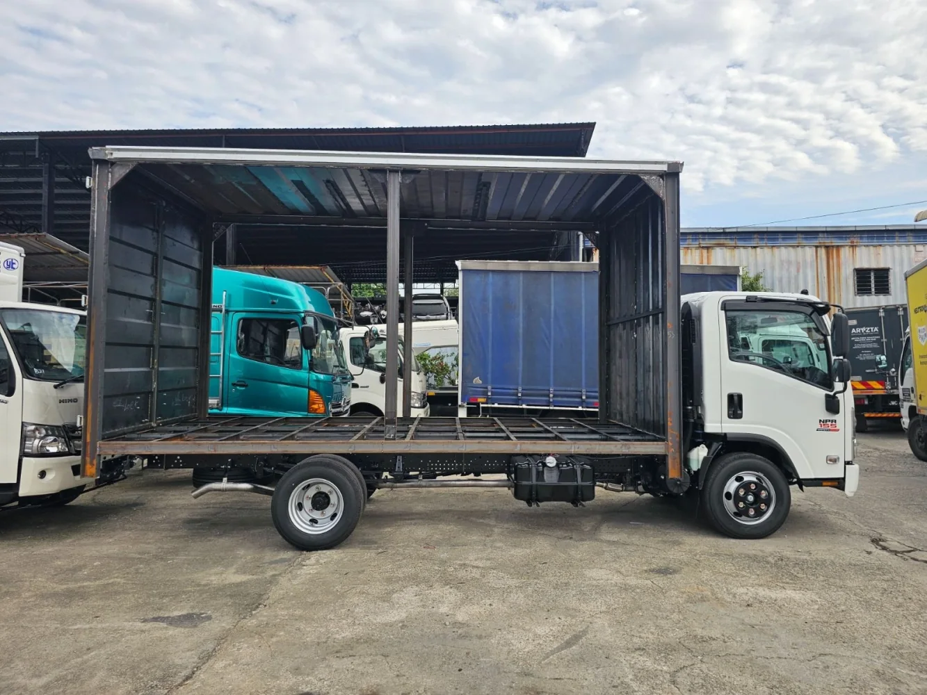 White Isuzu truck with an unfinished cargo-body frame