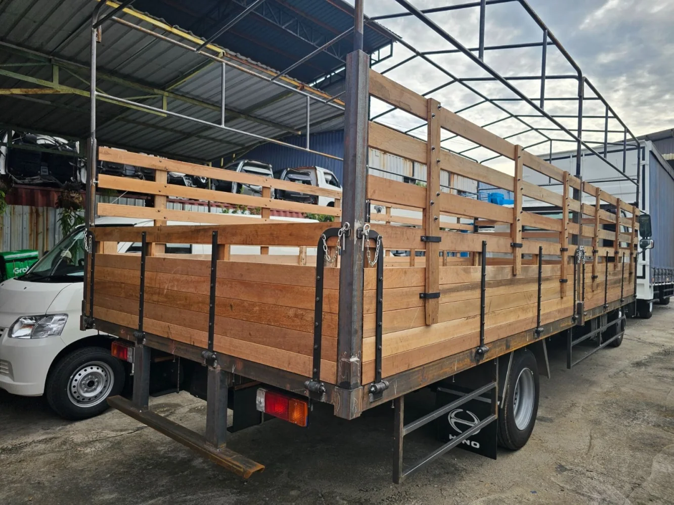 Wooden cargo body with sideboards and a metal canopy frame